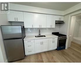 A kitchen with white cabinets and a stainless steel refrigerator.