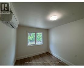 A room with a window and an air conditioner mounted on the wall.