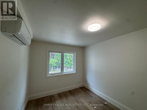 A room with a window and an air conditioner mounted on the wall.