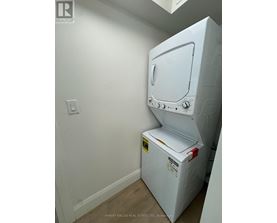 A white oven in a room with a light switch on the wall.