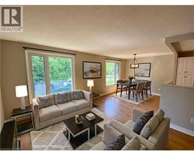A living room with a couch, coffee table, and a dining table.