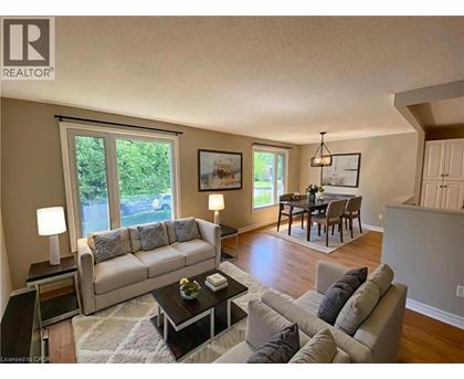 A living room with a couch, coffee table, and a dining table.