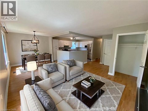A well-lit living room with a white sofa set and a coffee table.