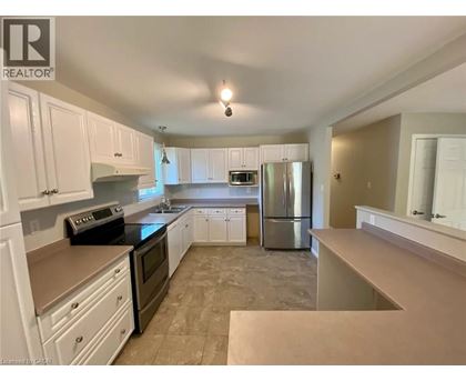 A kitchen with white cabinets and a black stove top oven.