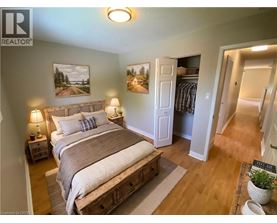 A bedroom with a large bed and a painting on the wall.