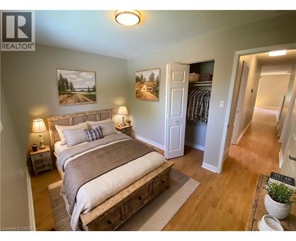 A bedroom with a large bed and a painting on the wall.