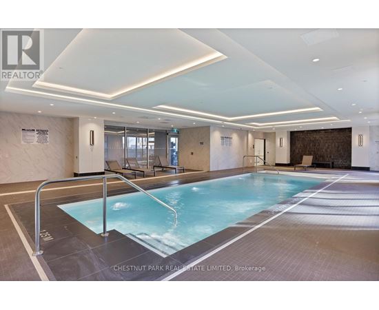 A large indoor swimming pool with a glass wall.