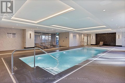 A large indoor swimming pool with a glass wall.