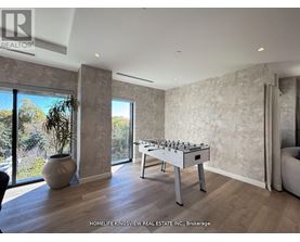 A foosball table sits in a room with a view of trees outside.