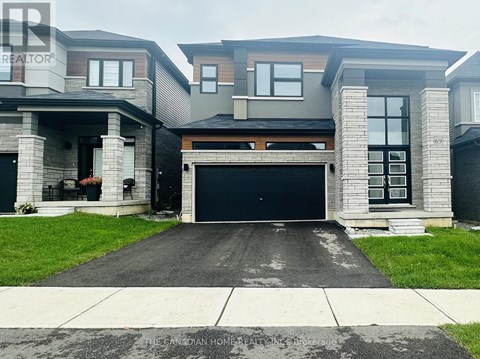 A modern house with a grey garage door is for sale.