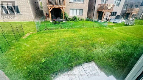 A green lawn in front of a building with a sign that says REALTOR.