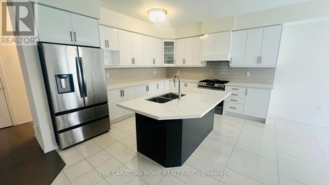 A modern kitchen with white cabinets and a black island.