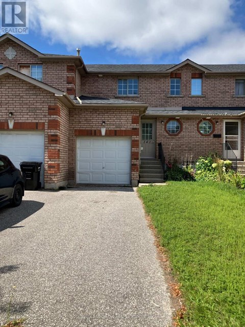 A house with a driveway and a car parked in front.