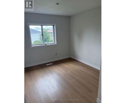A room with a window and wooden flooring.