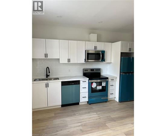 A kitchen with white cabinets and a blue dishwasher.
