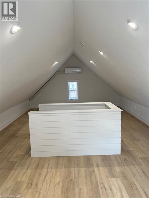 A white box with a window in the middle is on a wooden floor.