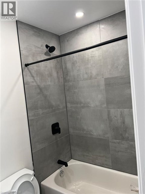 A bathroom with a toilet, a bathtub and a shower.
