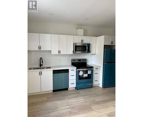 A kitchen with white cabinets and a blue dishwasher.
