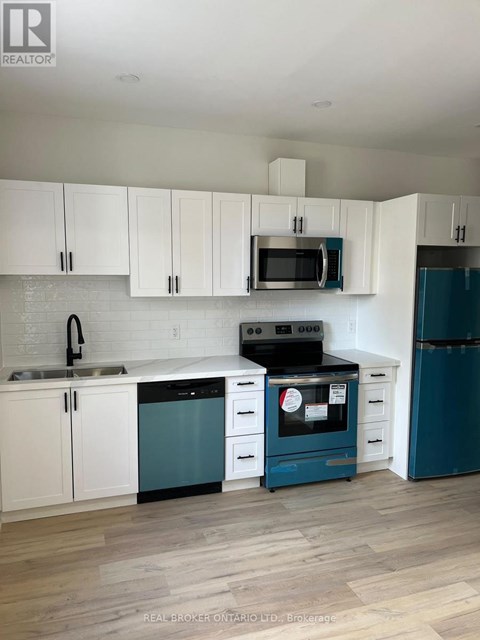A kitchen with white cabinets and a blue dishwasher.