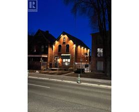 A house with a lit up sign that says REAL BROKER ONTARIO LTD. Brokerage.