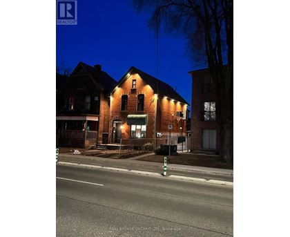A house with a lit up sign that says REAL BROKER ONTARIO LTD. Brokerage.