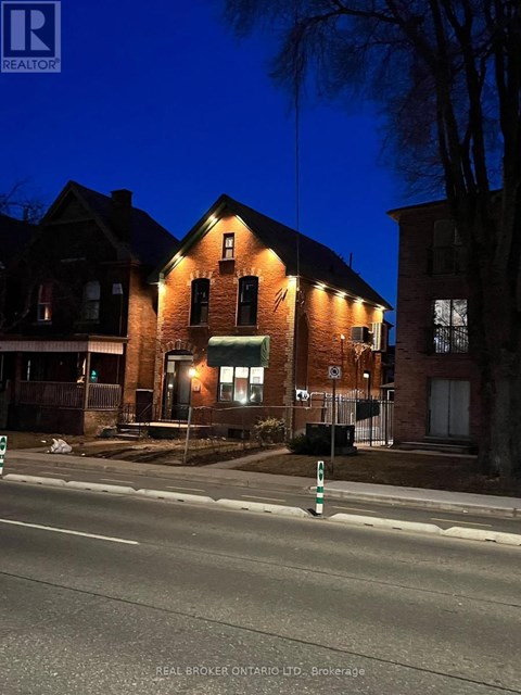 A house with a lit up sign that says REAL BROKER ONTARIO LTD. Brokerage.