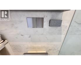 A bathroom with a marble wall and a window.