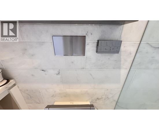 A bathroom with a marble wall and a window.
