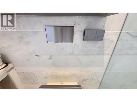 A bathroom with a marble wall and a window.