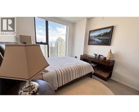 A bedroom with a bed, a lamp, and a painting on the wall.