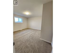 A room with a window and carpeted floor.