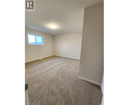 A room with a window and carpeted floor.