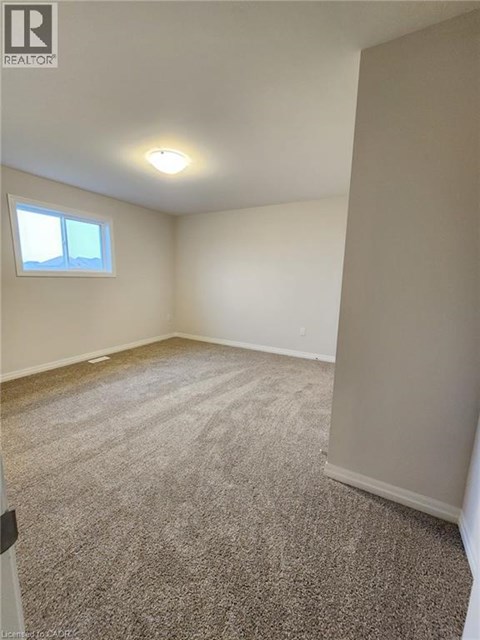 A room with a window and carpeted floor.