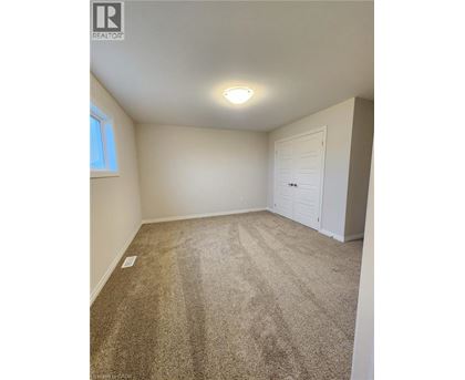 A room with a carpeted floor and a white door.