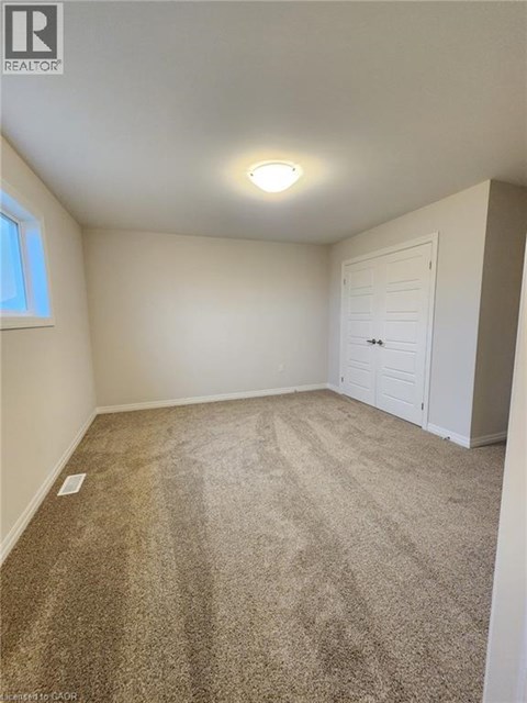 A room with a carpeted floor and a white door.