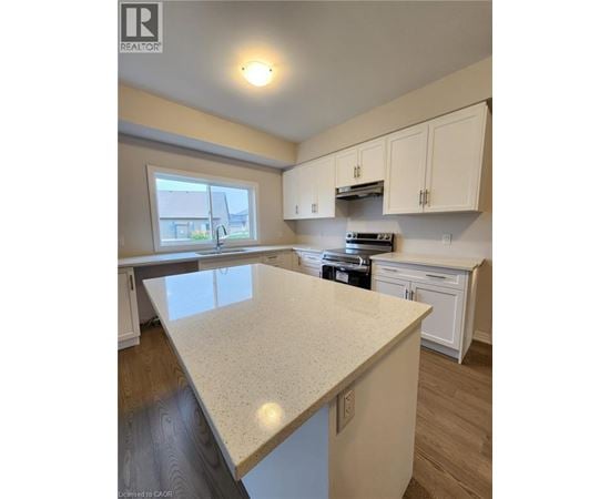 A kitchen with white cabinets and a large island.