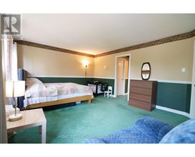 A bedroom with a bed, desk, and chair.
