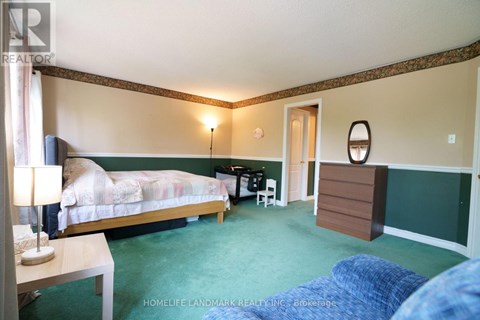 A bedroom with a bed, desk, and chair.