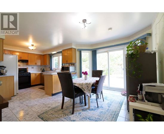 A kitchen with a table and chairs in front of a window.
