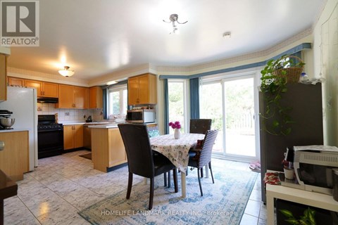 A kitchen with a table and chairs in front of a window.