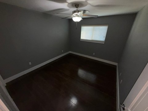 A room with a ceiling fan and a window.