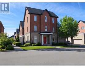 A large brick house with a red door is for sale.