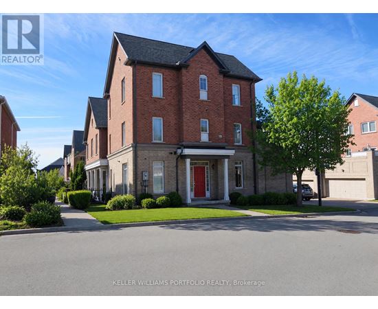 A large brick house with a red door is for sale.