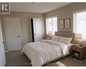 A bedroom with a large bed and a nightstand with a lamp.