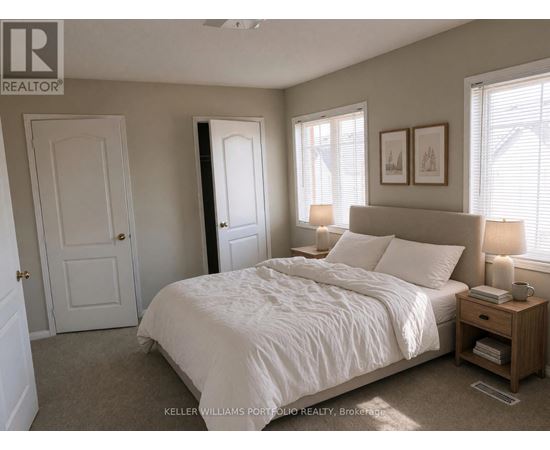 A bedroom with a large bed and a nightstand with a lamp.