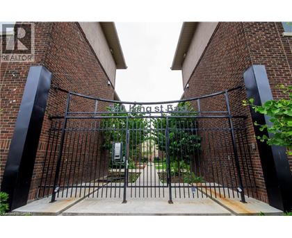 A black metal gate with a brick wall on either side.