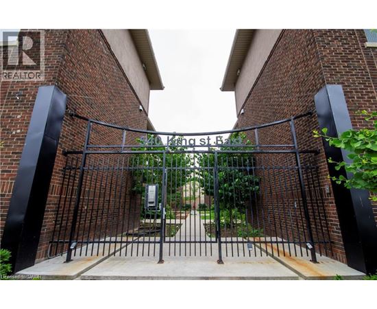 A black metal gate with a brick wall on either side.