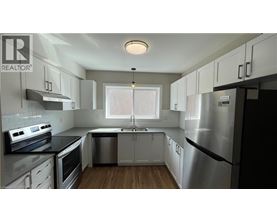 A modern kitchen with stainless steel appliances and white cabinets.