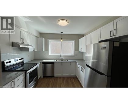 A modern kitchen with stainless steel appliances and white cabinets.