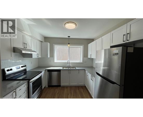 A modern kitchen with stainless steel appliances and white cabinets.